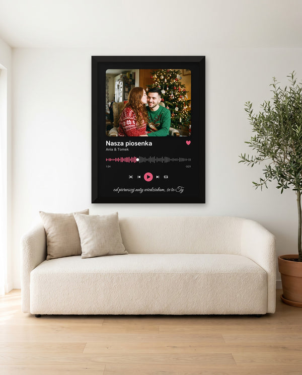Plakat Nasza piosenka – odtwarzacz ze zdjęciem w czarnej drewnianej ramie nad sofą