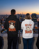 Two friends seen from behind in the black and white Here For The Boos hoodies