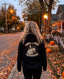 Woman seen from behind in a black hoodie with the custom couple Halloween portrait on the back