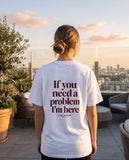 Person wearing the white If You Need A Problem I'm Here t-shirt, seen from behind