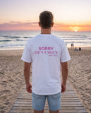 Man seen from behind wearing the white Sorry He's Taken t-shirt
