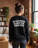 Person wearing the black My Girlfriend Is Hotter Than You crewneck sweatshirt, seen from behind