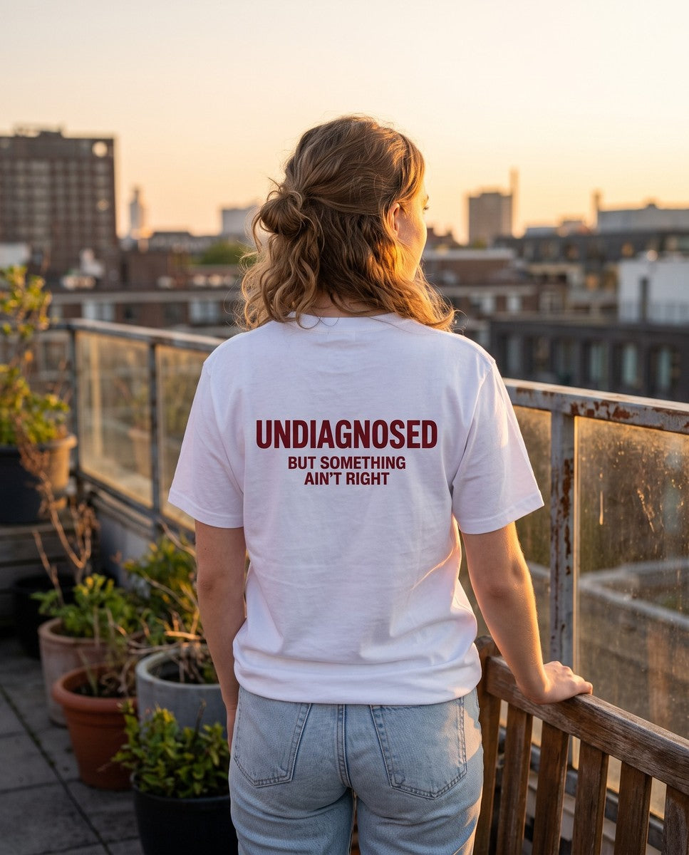 Person wearing the white Undiagnosed But Something Ain't Right t-shirt, seen from behind