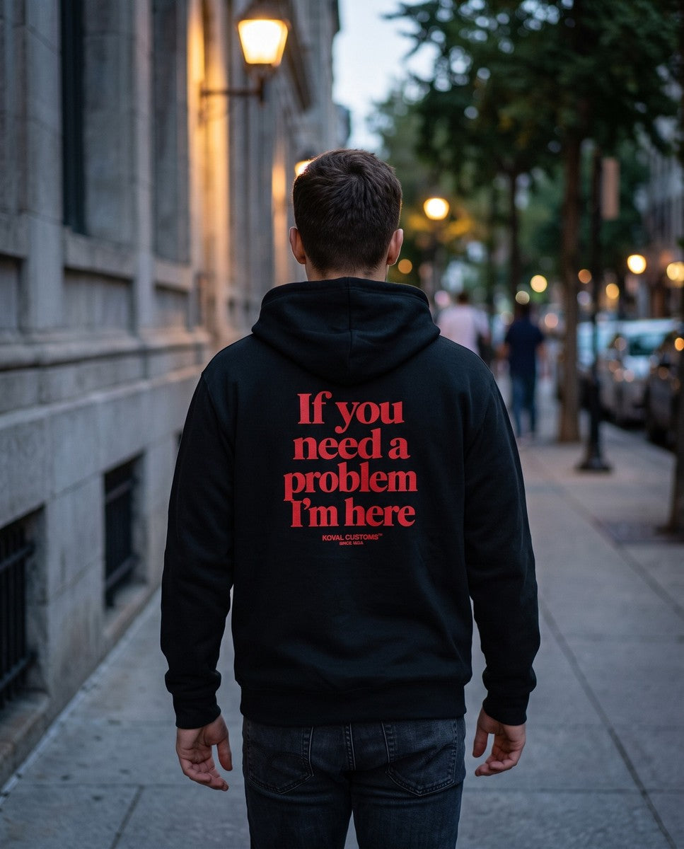 Person wearing the black If You Need A Problem I'm Here zip hoodie, seen from behind