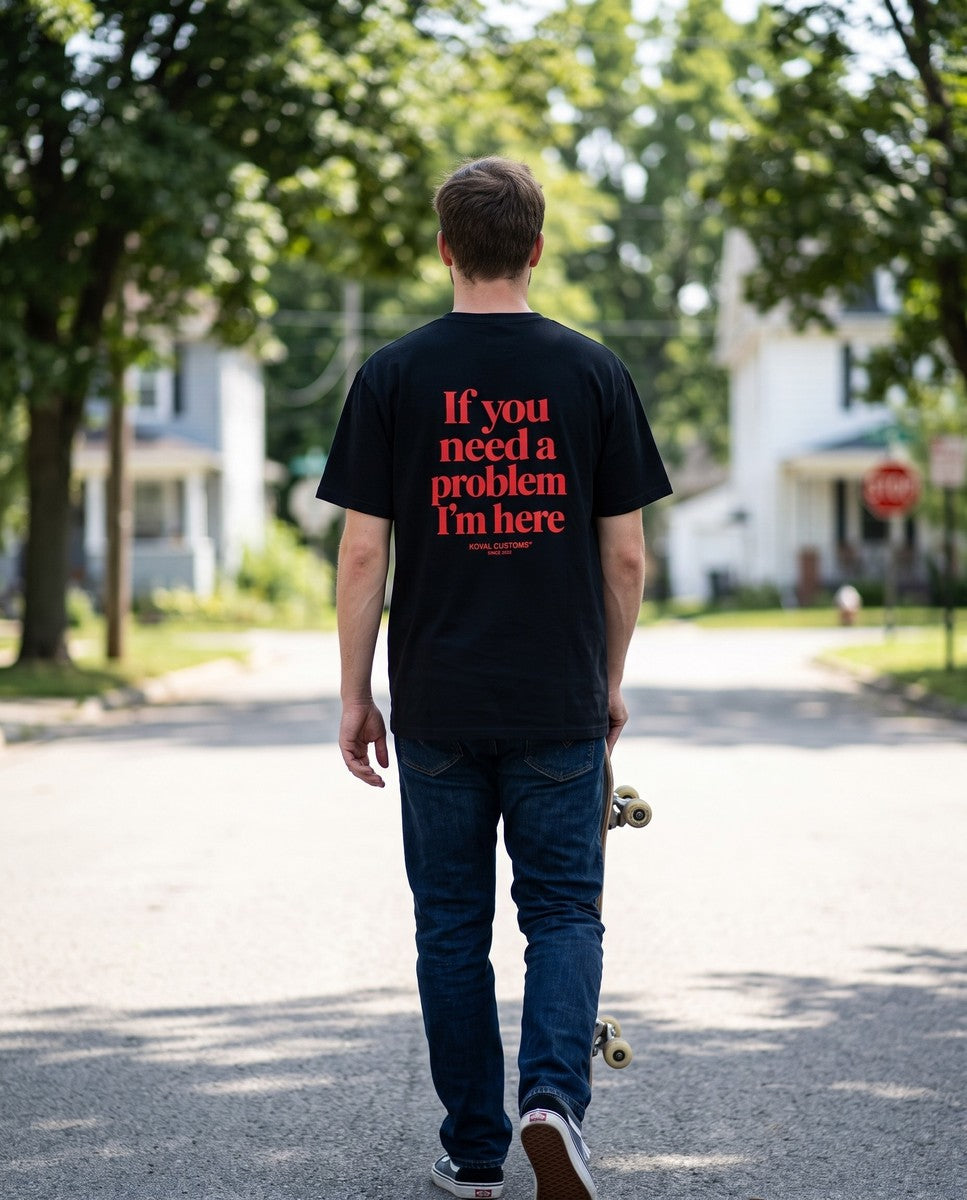 Person wearing the black If You Need A Problem I'm Here t-shirt, seen from behind
