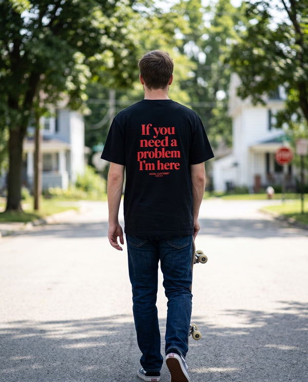 Person wearing the black If You Need A Problem I'm Here t-shirt, seen from behind