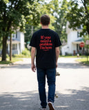 Person wearing the black If You Need A Problem I'm Here t-shirt, seen from behind