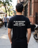 Man seen from behind wearing the black I'm The Investment Your Parents Warned You About t-shirt