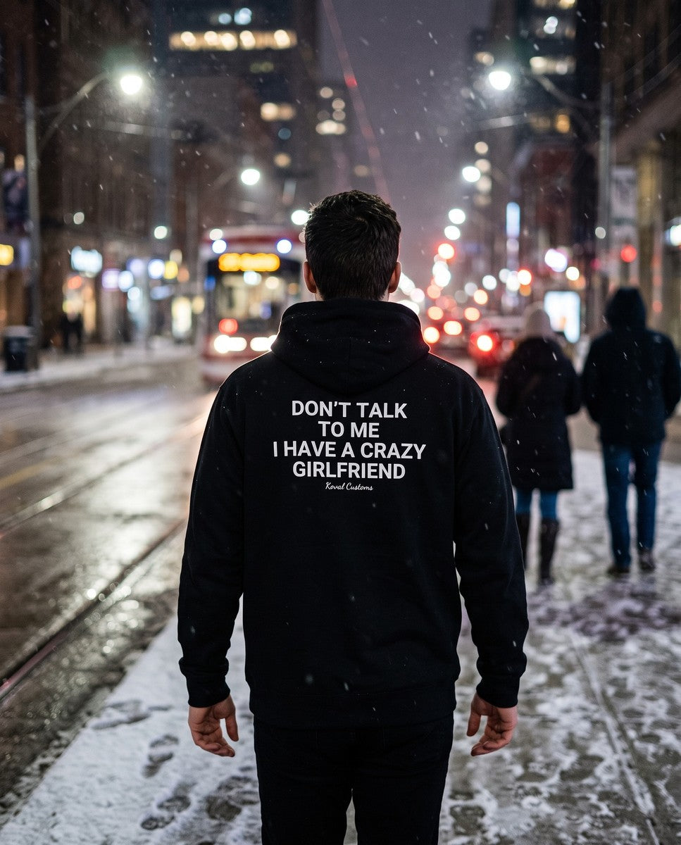 Man seen from behind wearing the black Don't Talk To Me I Have A Crazy Girlfriend hoodie