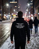 Man seen from behind wearing the black Don't Talk To Me I Have A Crazy Girlfriend hoodie