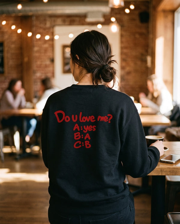 Person wearing the black Do U Love Me crewneck sweatshirt, seen from behind