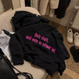 [DE] Schwarzer Hoodie mit pinker Stickerei: Bleib stark, auch wenn es schwer ist