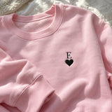 [US] Initial With Heart Embroidered Sweatshirt - pink crewneck sweatshirt laid flat