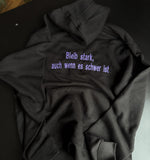 [DE] Schwarzer Hoodie mit lila Stickerei: Bleib stark, auch wenn es schwer ist