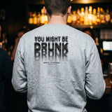 Man at a bar counter in a sport grey crewneck sweatshirt with a motion-blur You Might Be Drunk print across the back
