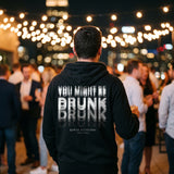 Man at a rooftop party in a black hoodie with a motion-blur You Might Be Drunk print across the back
