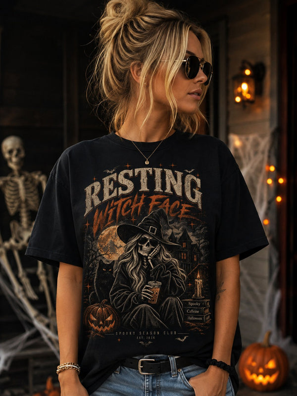 Woman on a Halloween porch wearing the black Resting Witch Face tee with the big front print