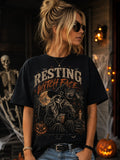 Woman on a Halloween porch wearing the black Resting Witch Face tee with the big front print