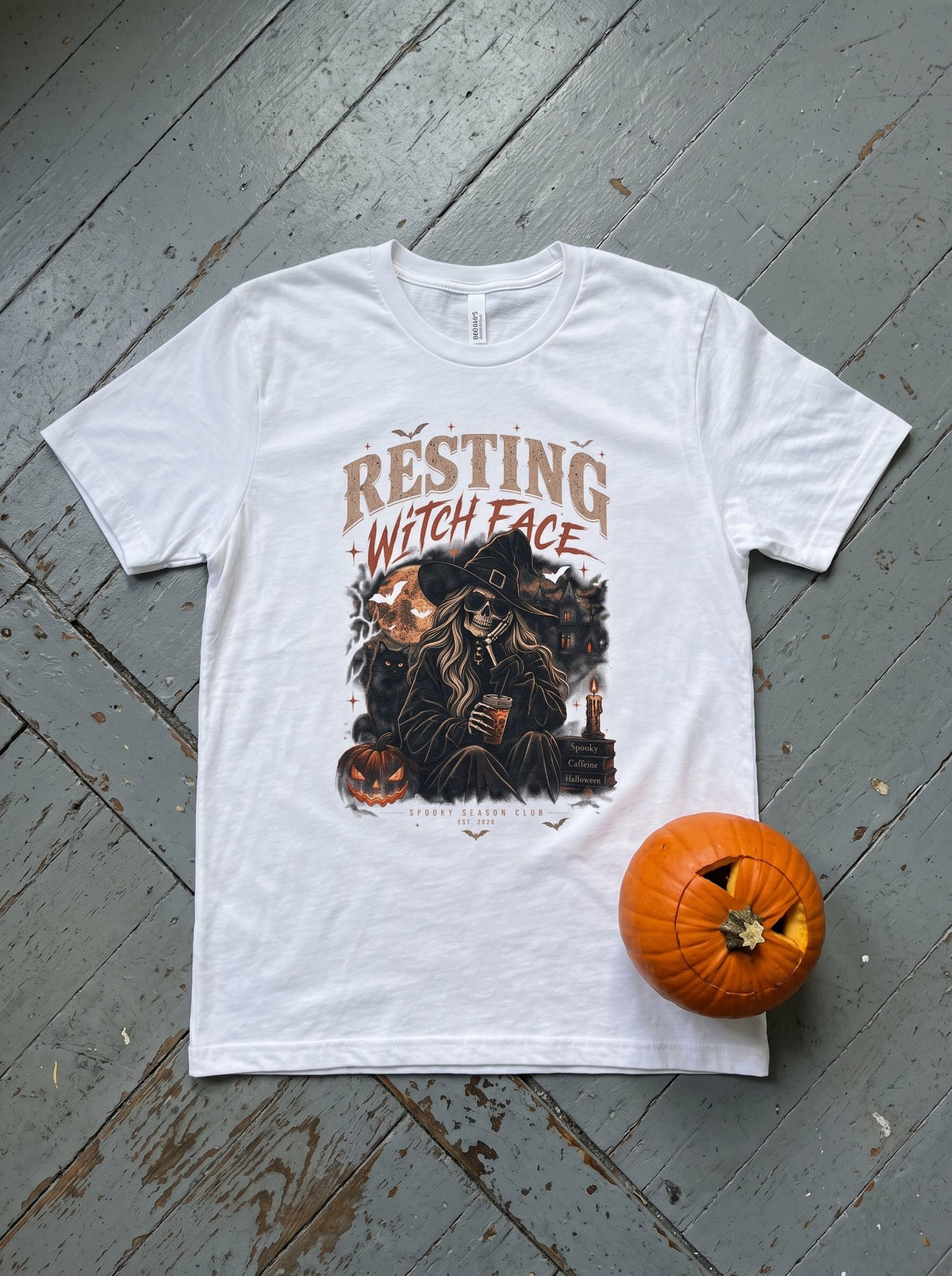 White Resting Witch Face t-shirt flat-lay with a carved pumpkin