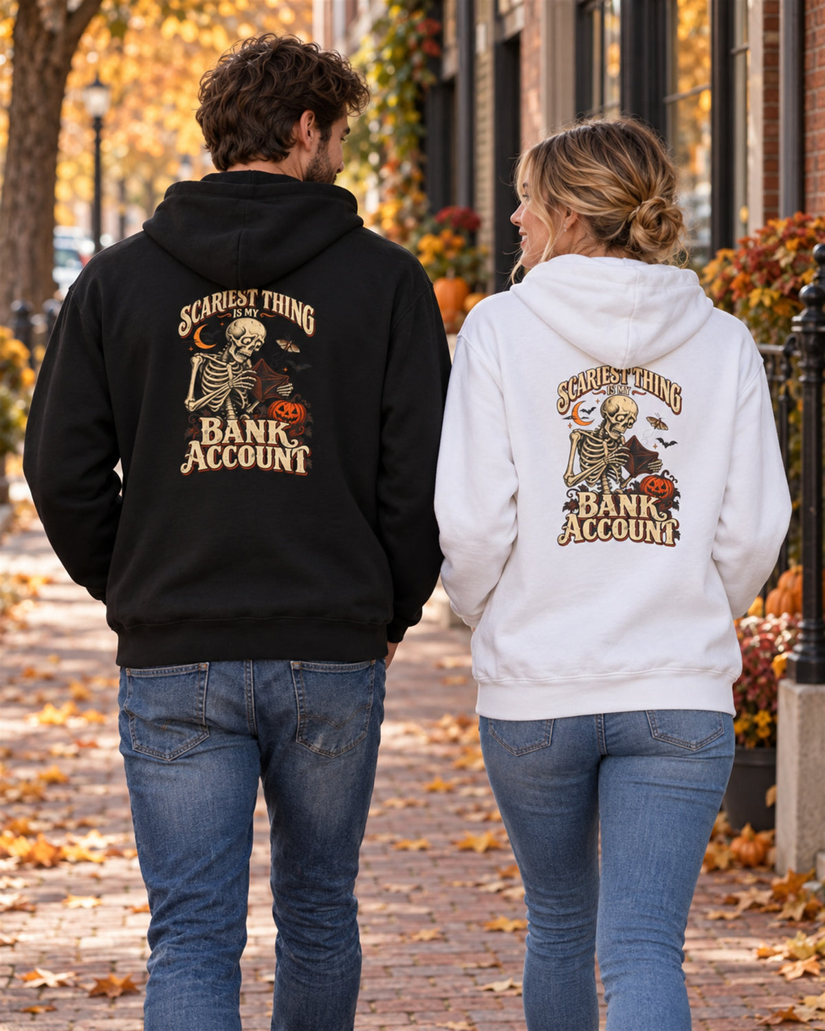 Couple walking down an autumn street in the black and white Scariest Thing Is My Bank Account hoodies, back print